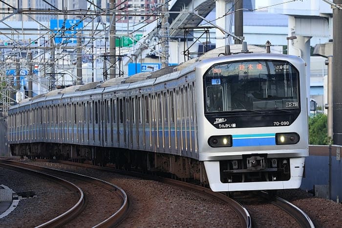 カーブした線路を走行する通勤電車の写真