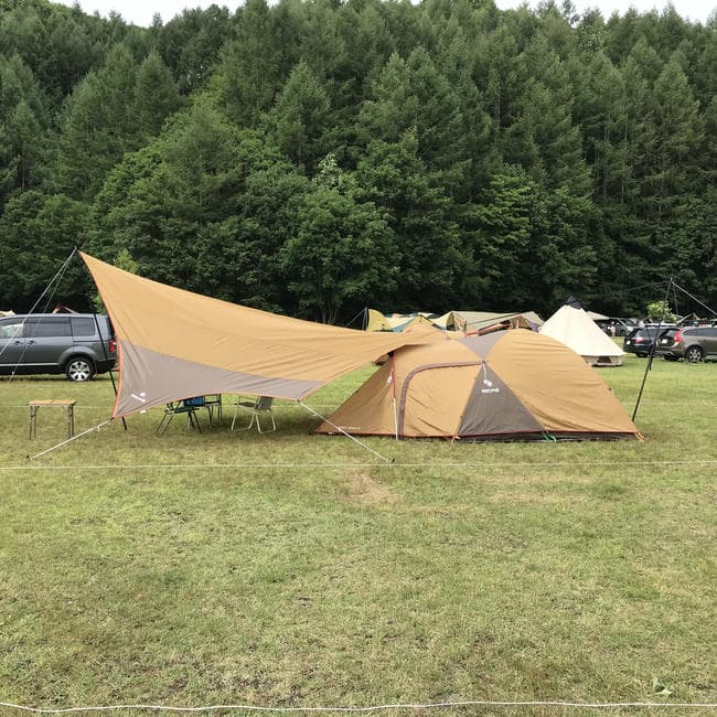 スノーピークのアメニティドームとアメニティタープを小川張りで連結した芝生サイトの設営風景