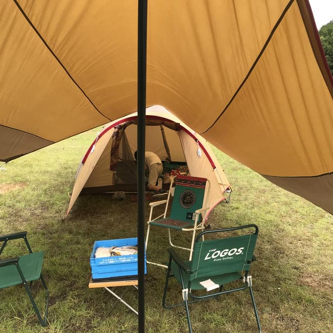 小川張りしたスノーピークのアメニティタープの下からアメニティドームの出入り口とリビングスペースを見た内景