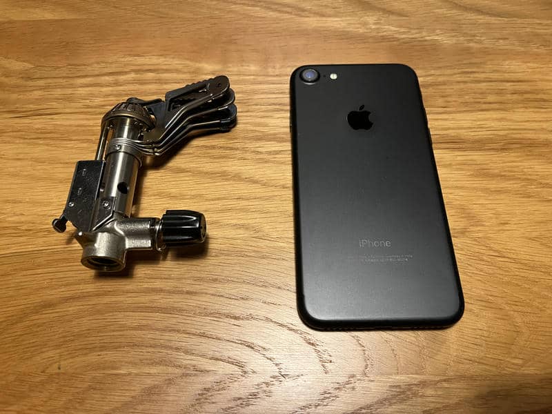 木製テーブルに置いたプリムスP-153と大きさ比較用のiPhone